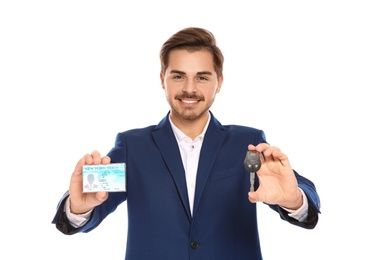 Happy young businessman with driving license and car key on white background