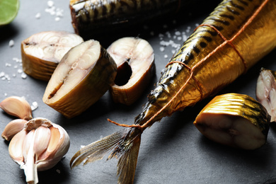 Tasty smoked fish on black table, closeup