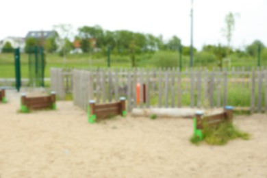 Photo of Wooden rover jump over on animal training area outdoors, blurred view