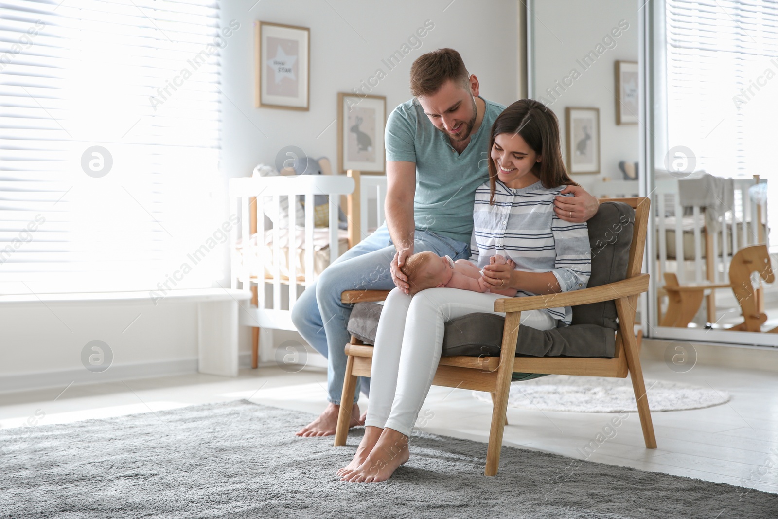 Photo of Happy couple with their newborn baby at home. Space for text