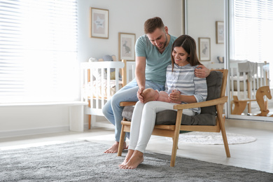 Photo of Happy couple with their newborn baby at home. Space for text