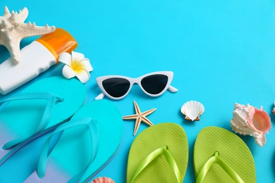 Photo of Composition with different flip flops on blue background, space for text. Summer beach accessories