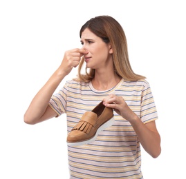Photo of Woman feeling bad smell from shoe on white background. Air freshener