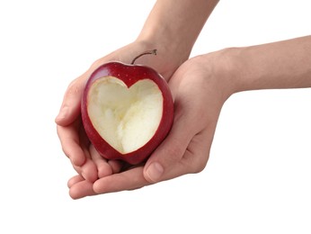 Photo of Woman holding red apple with carved heart on white background, closeup