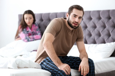 Photo of Young couple ignoring each other after having argument in bedroom