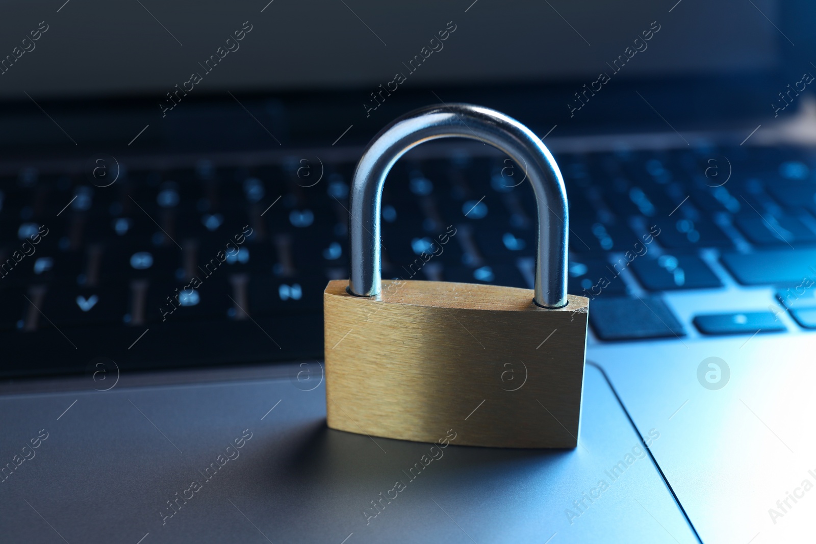 Photo of Cyber security. Metal padlock on laptop, closeup