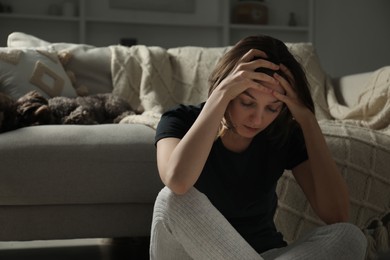 Photo of Sad young woman and her dog at home