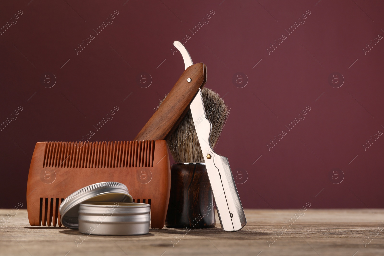 Photo of Moustache and beard styling tools on wooden table. Space for text