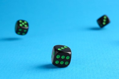 Photo of Many black game dices on light blue background