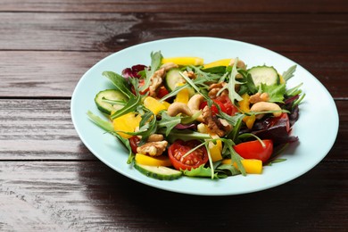 Tasty fresh vegetarian salad on dark wooden table