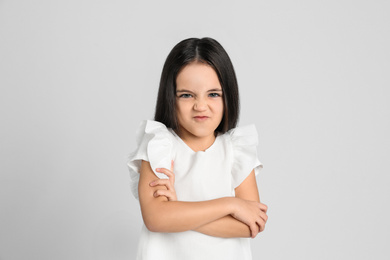 Portrait of cute little girl on light grey background