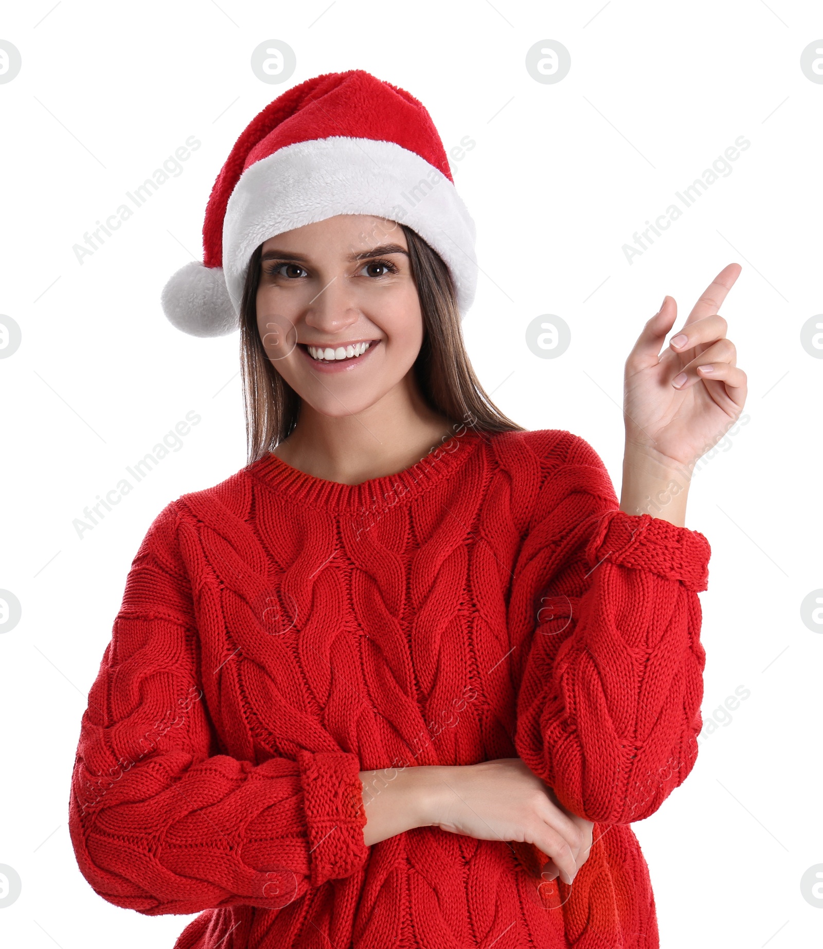 Photo of Pretty woman in Santa hat and red sweater pointing on white background