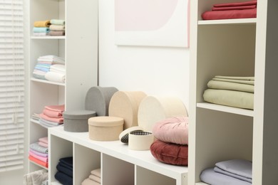Photo of Different colorful bed linens and decorative boxes on display in home textiles store