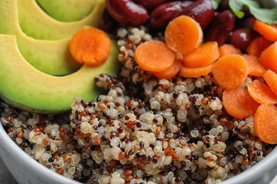 Photo of Healthy quinoa salad with vegetables in bowl, closeup