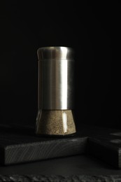 Pepper shaker on table against black background