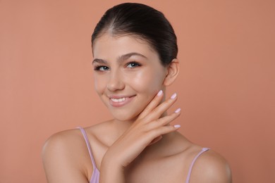 Photo of Portrait of pretty girl on pale coral background. Beautiful face with perfect smooth skin