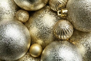 Beautiful shiny golden Christmas balls as background, top view