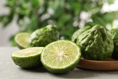 Photo of Fresh ripe bergamot fruits on light grey table against blurred background, closeup