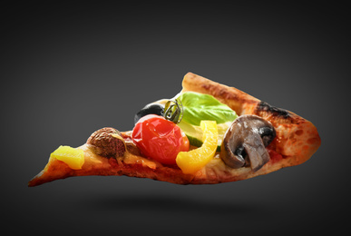 Slice of hot tasty vegetable pizza on dark background. Image for menu or poster