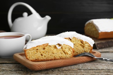 Photo of Pieces of homemade yogurt cake with cream on wooden table