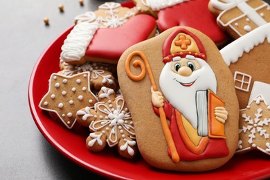 Photo of Tasty gingerbread cookies on grey table, closeup. St. Nicholas Day celebration