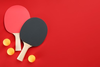 Photo of Ping pong rackets and balls on red background, flat lay. SPace for text