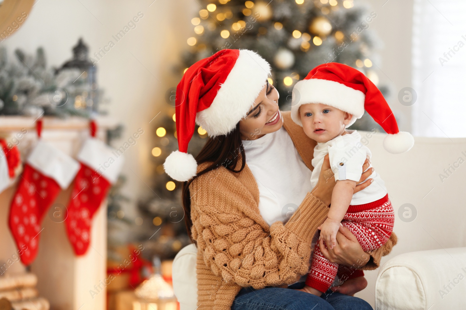 Photo of Mother with her cute baby at home, space for text. Christmas celebration