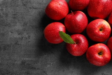 Photo of Fresh red apples with drops of water on grey background