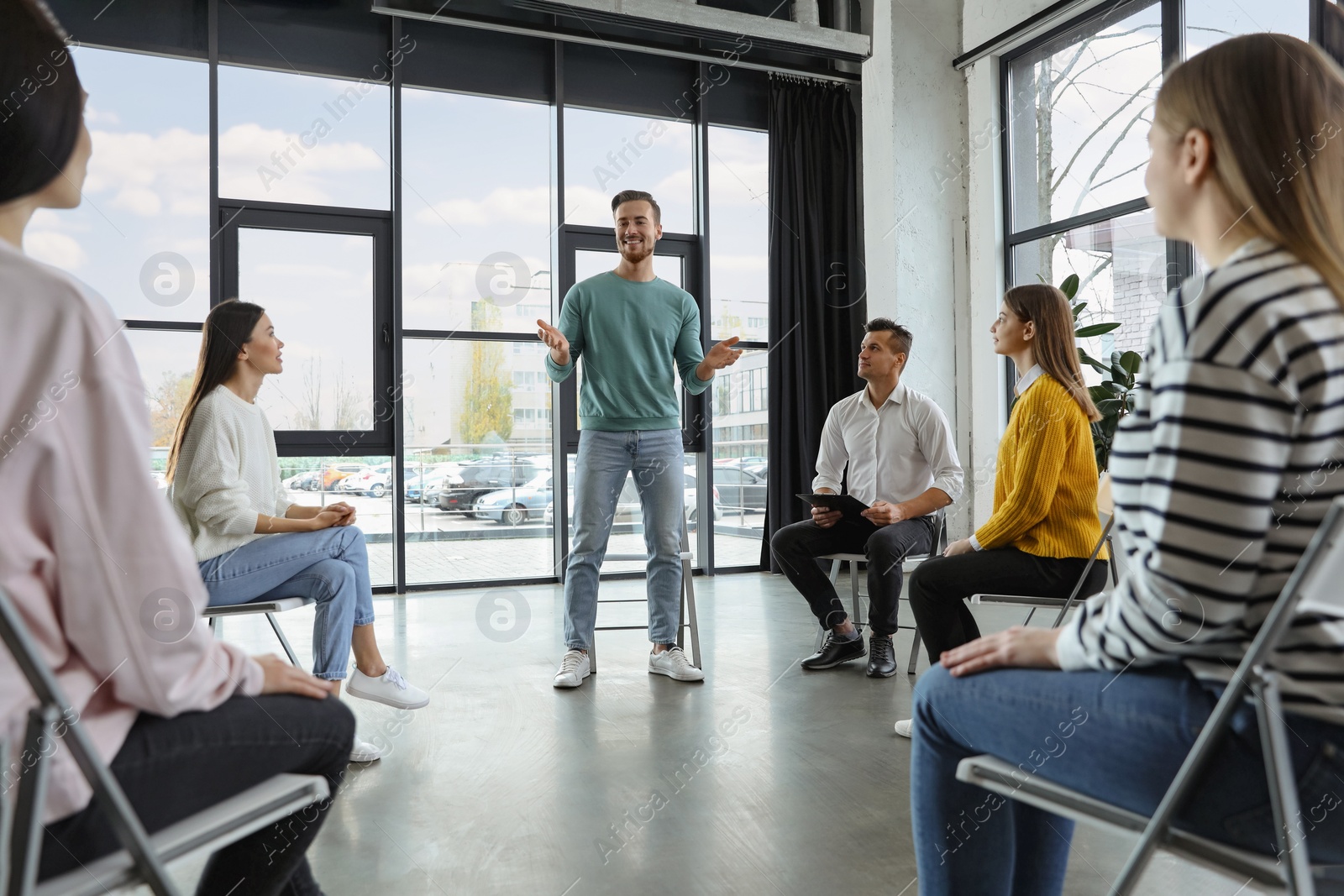 Photo of Psychotherapist working with patients in group therapy session indoors