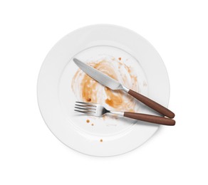 Dirty plate and cutlery on white background, top view