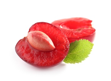 Halves of delicious ripe sweet cherry with leaf on white background