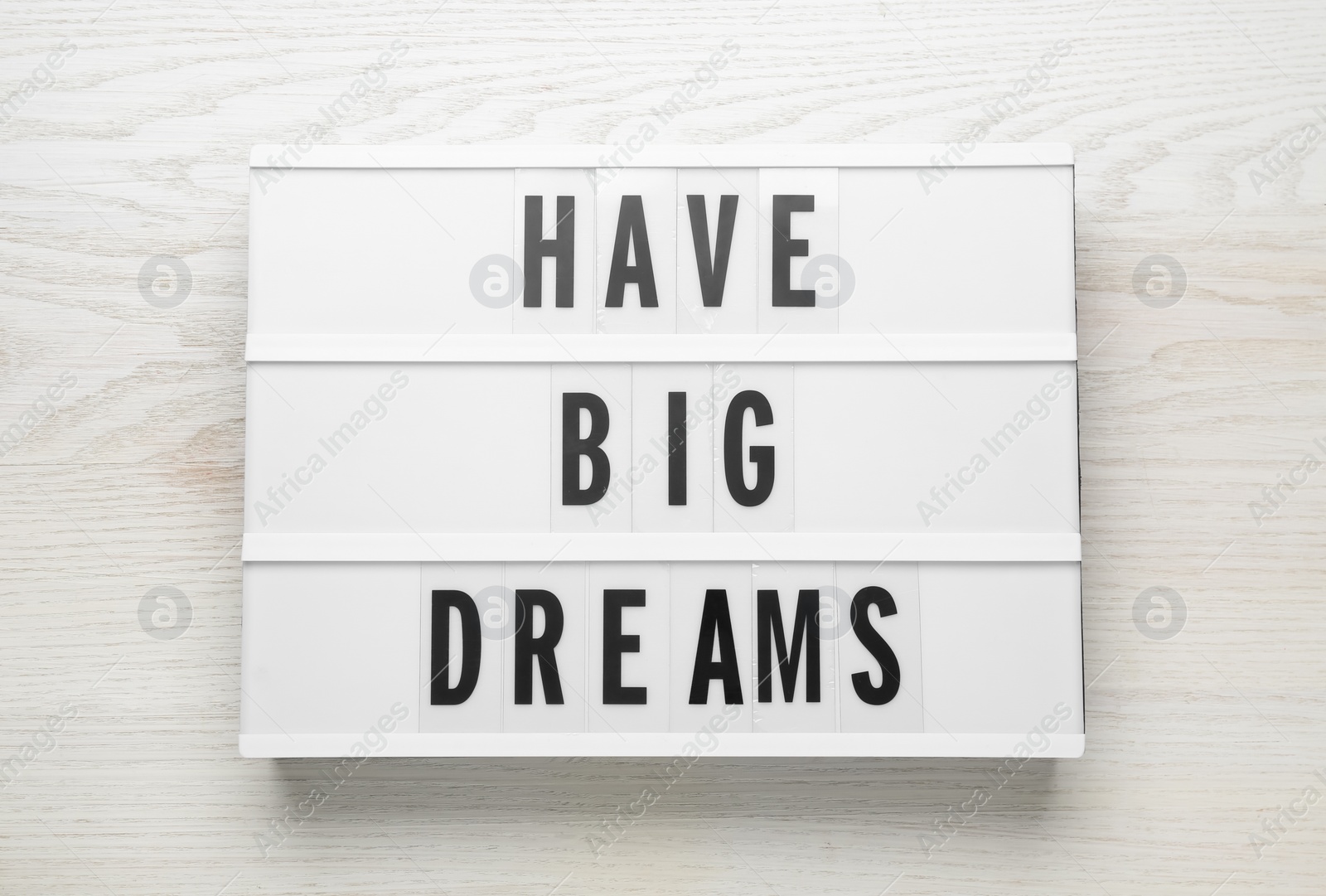 Photo of Lightbox with motivational quote Have Big Dreams on white wooden table, top view