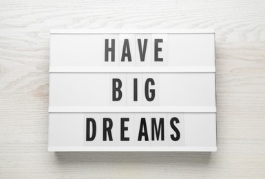 Photo of Lightbox with motivational quote Have Big Dreams on white wooden table, top view