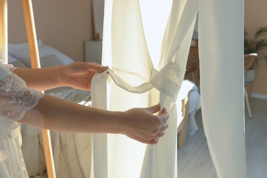 Photo of Bride with her beautiful wedding dress in room, closeup