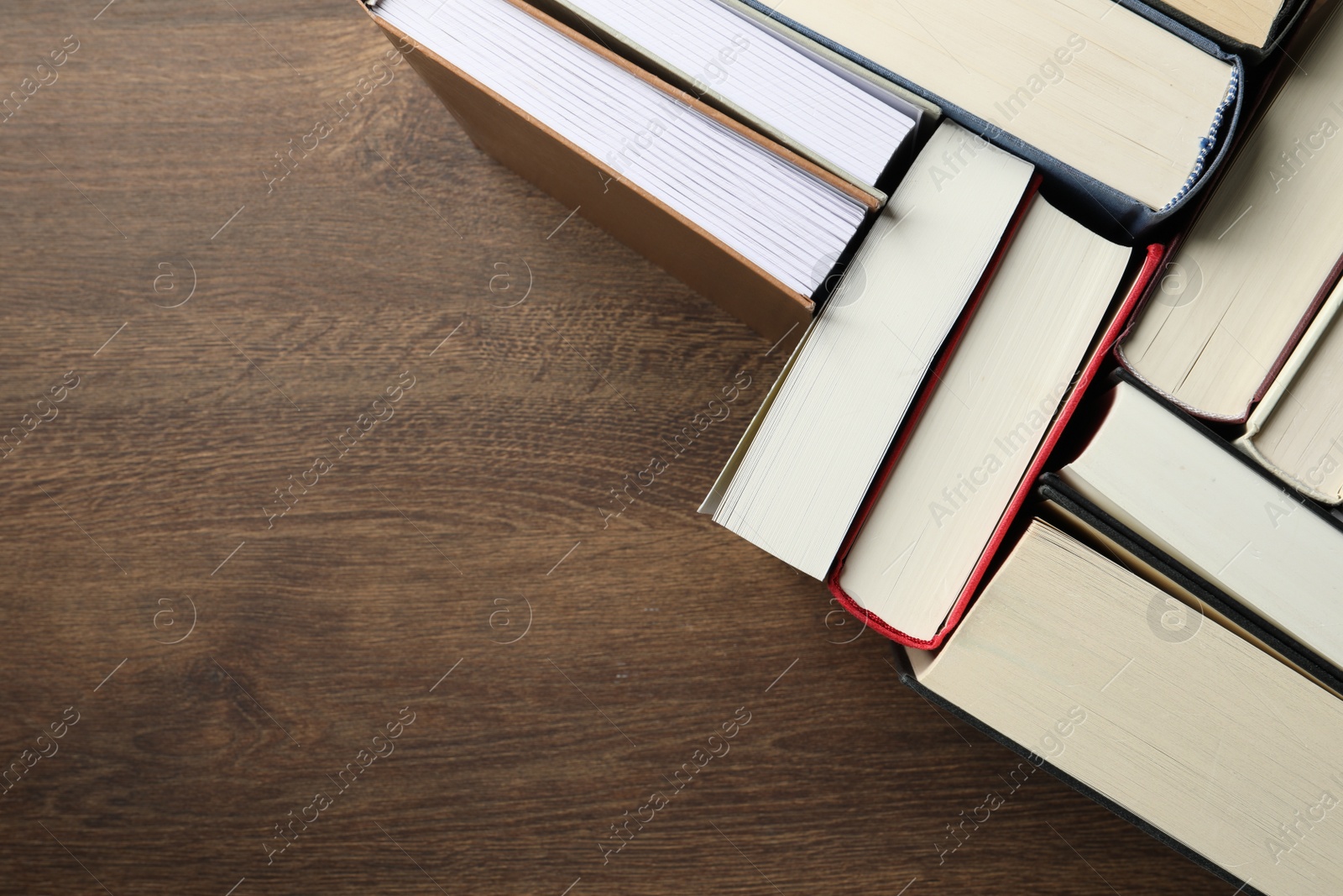 Photo of Hardcover books on wooden table, flat lay. Space for text