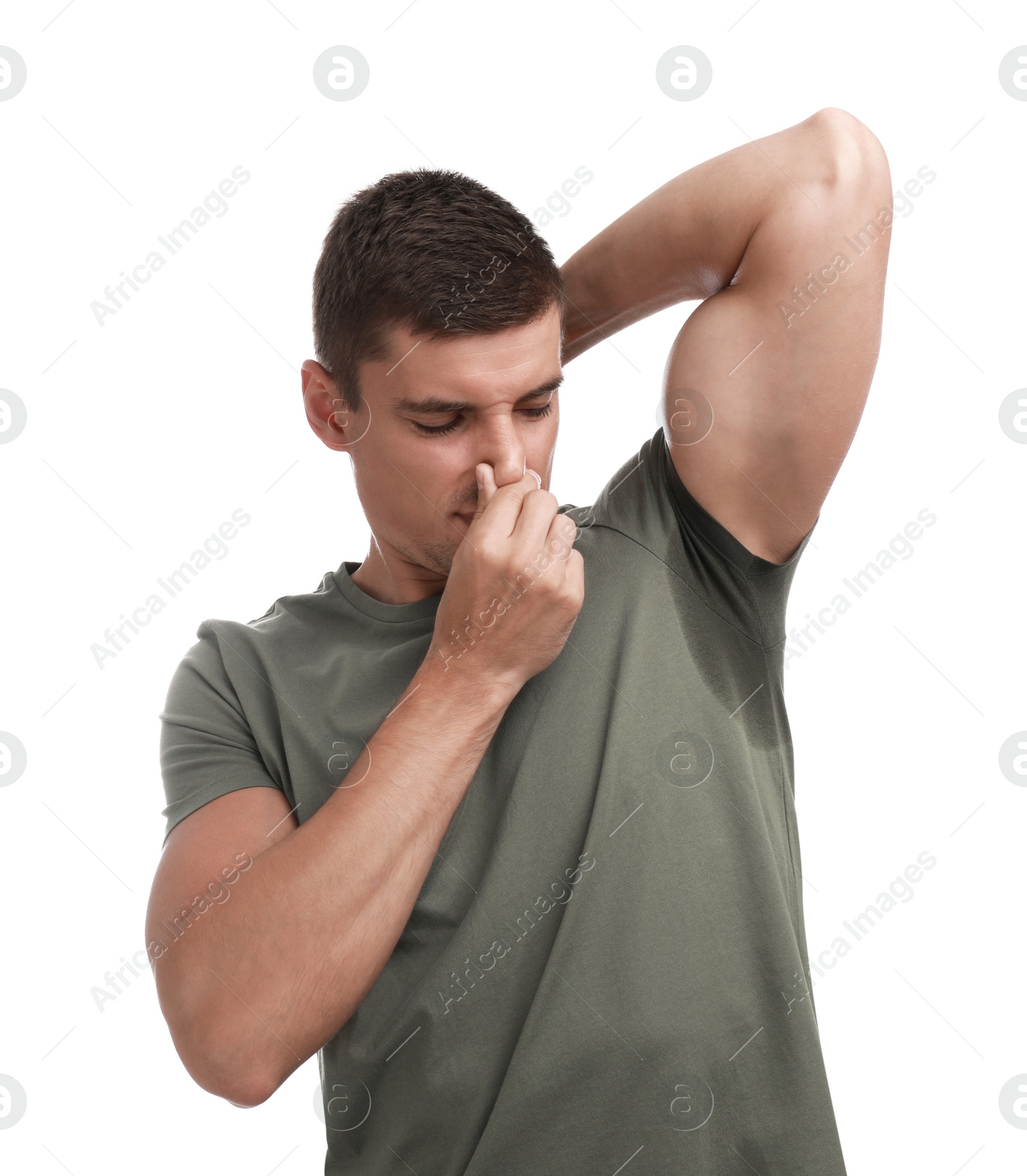 Photo of Young man with sweat stain on his clothes against white background. Using deodorant