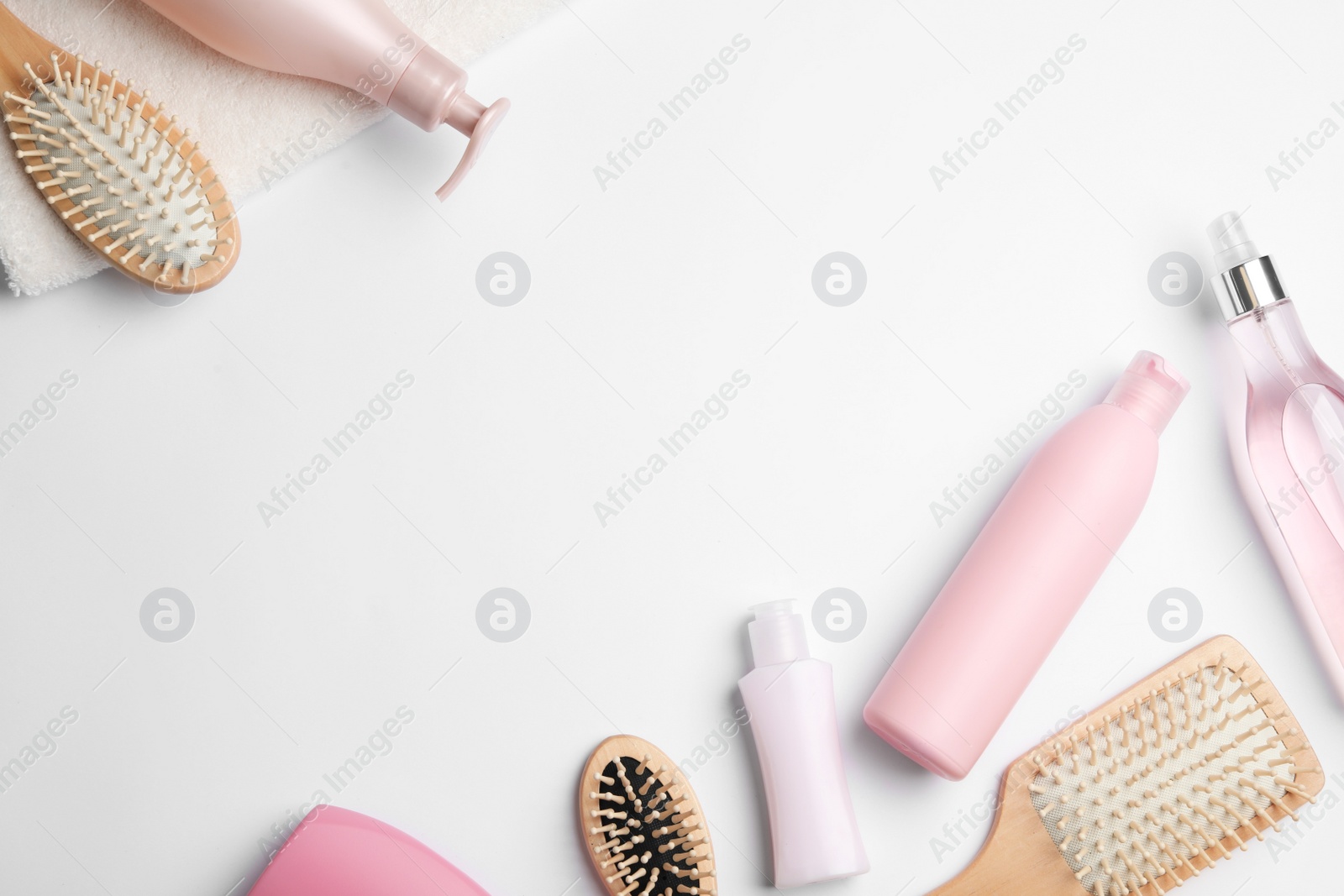 Photo of Flat lay composition with hair cosmetic products and tools on white background. Space for text