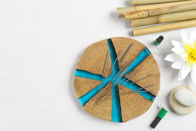 Photo of Flat lay composition with acupuncture needles on white wooden table. Space for text