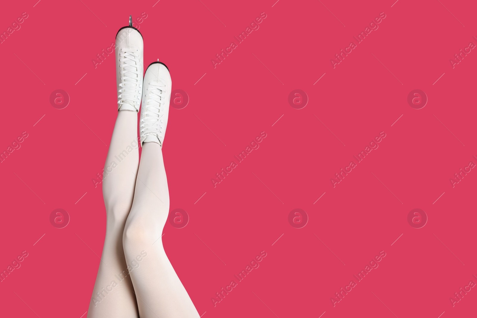 Photo of Woman in elegant white ice skates on pink background, closeup of legs. Space for text