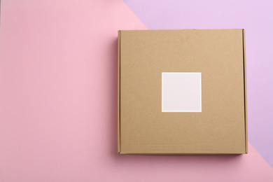 Cardboard box on color background, top view. Space for text