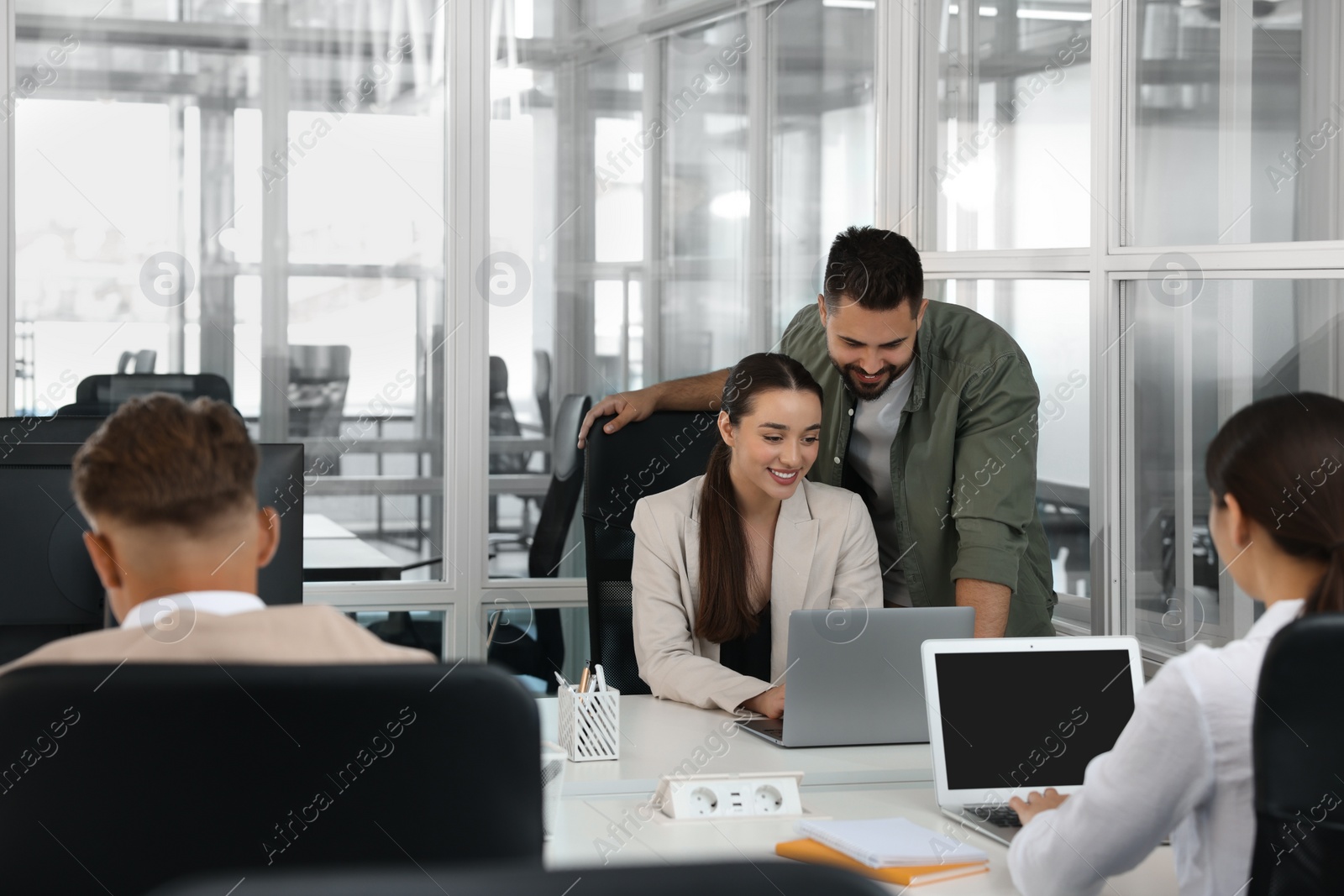 Photo of Colleagues working together in open plan office