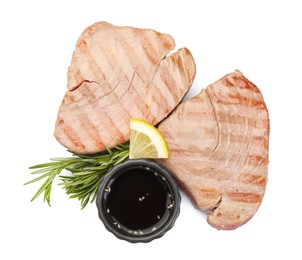 Photo of Delicious tuna steaks with sauce, lemon and rosemary isolated on white, top view