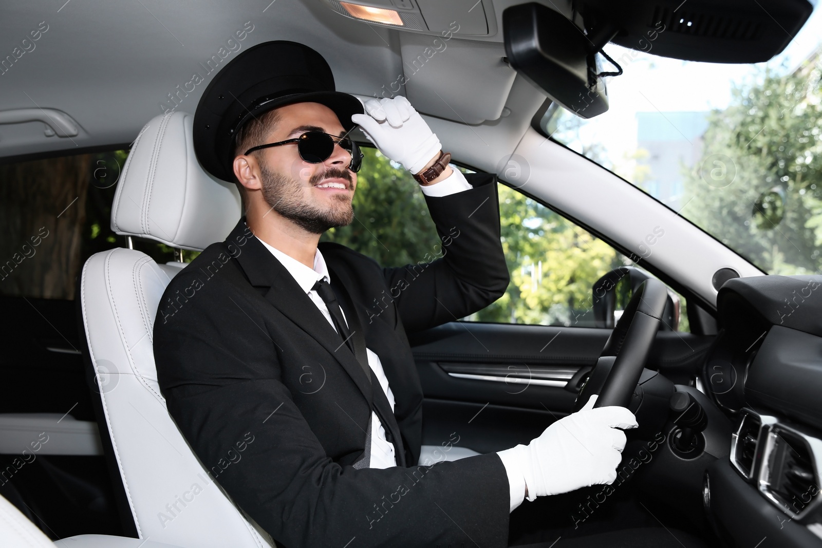 Photo of Young handsome driver in luxury car. Chauffeur service