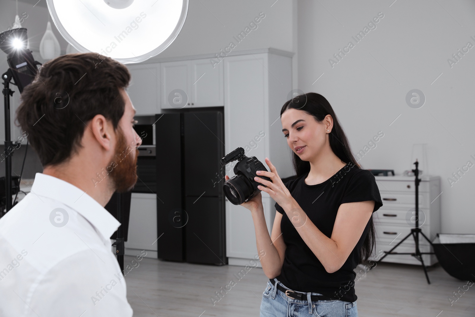 Photo of Professional photographer working with handsome model in modern photo studio