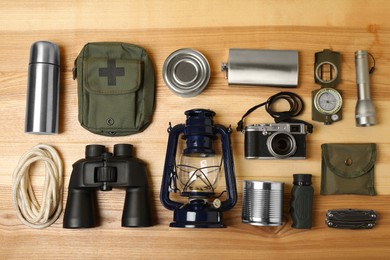 Photo of Set of traveler's equipment on wooden table, flat lay