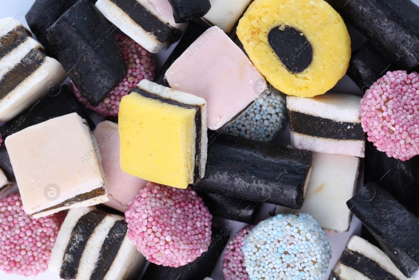 Photo of Many tasty liquorice candies on white background, top view