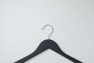 Empty black hanger on light grey background, top view. Space for text