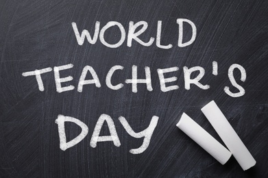 Image of Text World Teacher's Day and chalk on blackboard, top view. Greeting card design