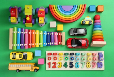 Different children's toys on green background, flat lay