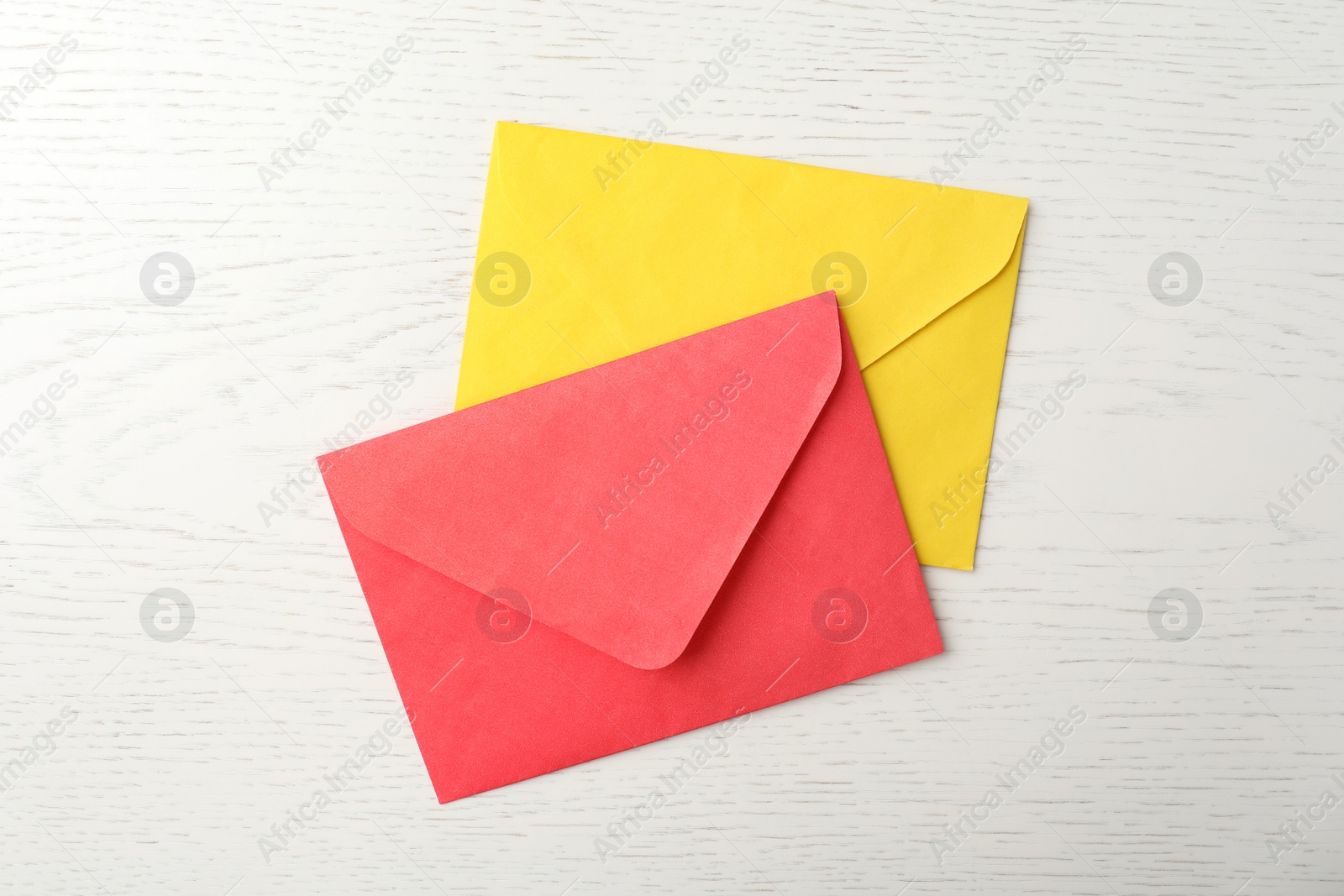 Photo of Paper envelopes on white wooden background, flat lay